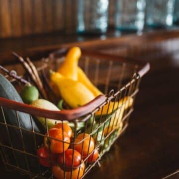 Basket of vegetables including tomatoes, zucchini and squash