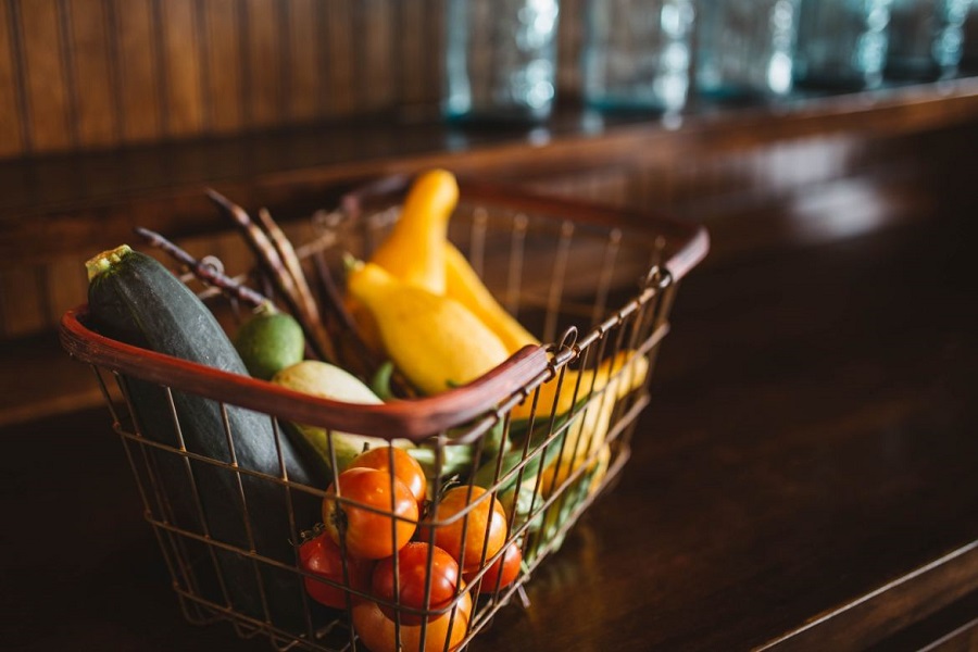 Basket of vegetables including tomatoes, zucchini and squash