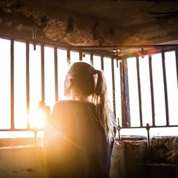 Woman in basement holding onto bars on the window