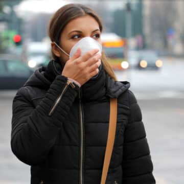 Woman with long haul COVID walking and wearing a mask.