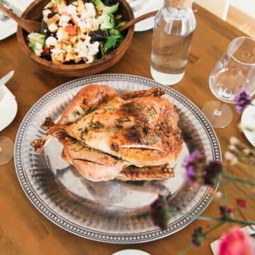 Turkey on a silver platter next to a wooden salad bowl