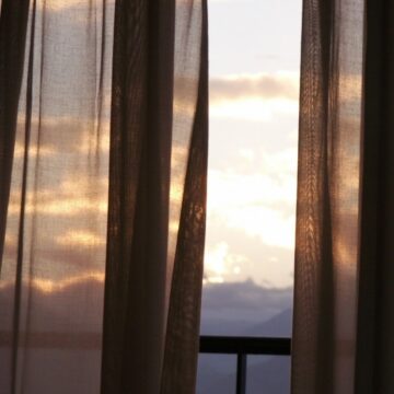 Window with black curtains over looking a balcony