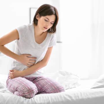 Woman leaning over in pain from chronic inflammation