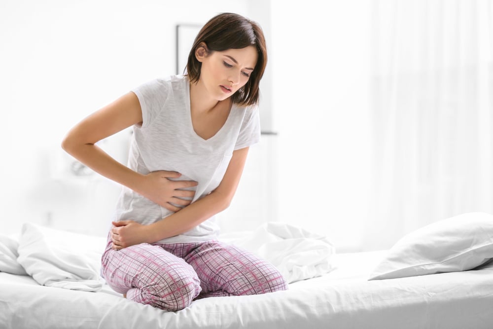 Woman leaning over in pain from chronic inflammation