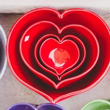 Four red, heart-shaped ceramic bowls nested into one another