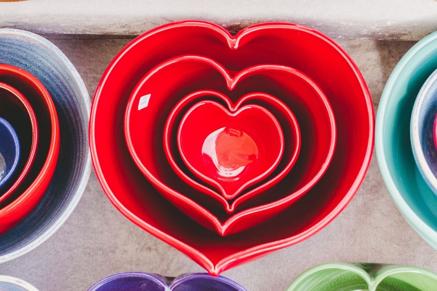 Four red, heart-shaped ceramic bowls nested into one another