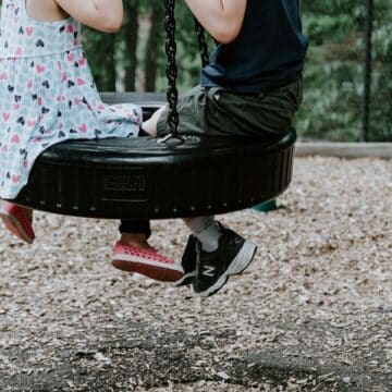 A boy and a girl on the tireswing