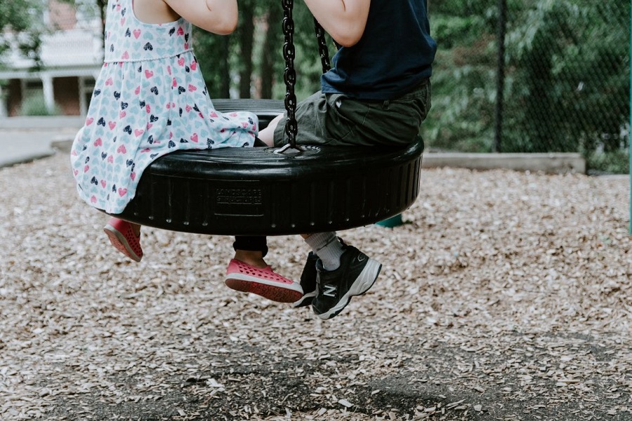 A boy and a girl on the tireswing