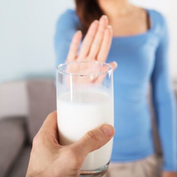 Woman with a stomach ache from drinking cow’s milk and dairy