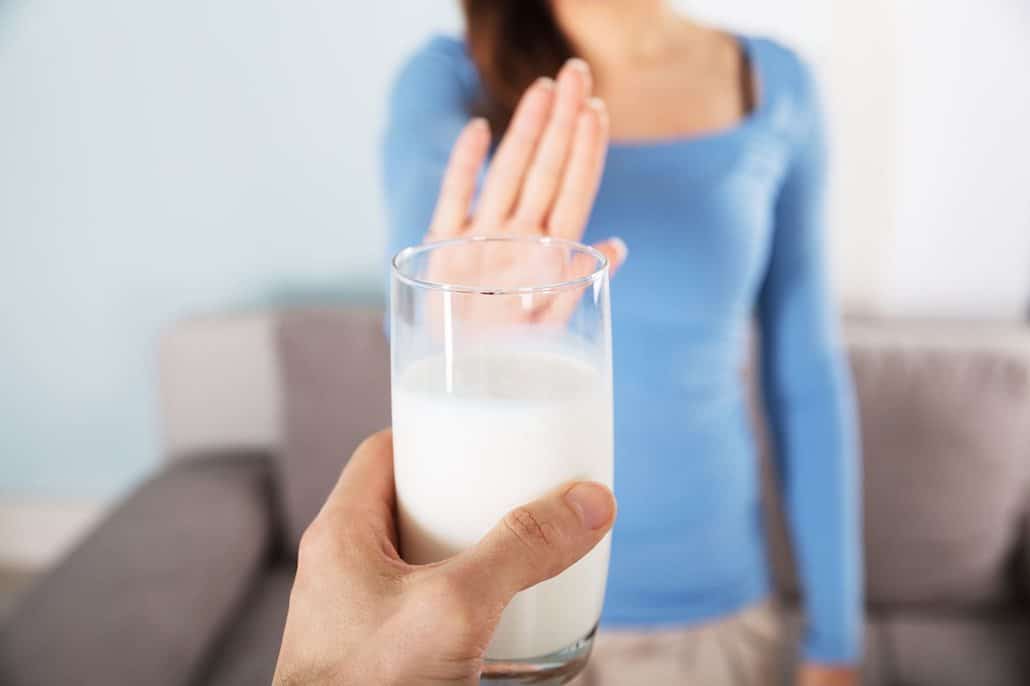 Woman with a stomach ache from drinking cow’s milk and dairy