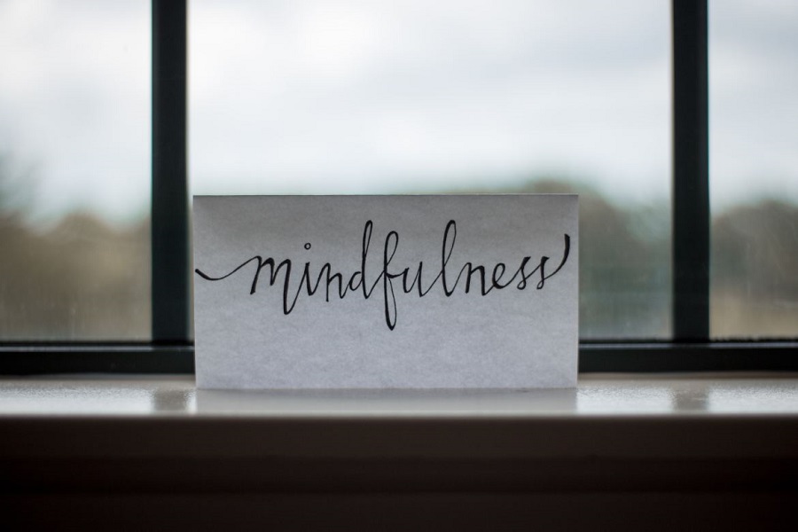 white paper with mindfulness written on it in front of a window