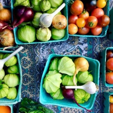 Teal containers of veggies at a farmer's market