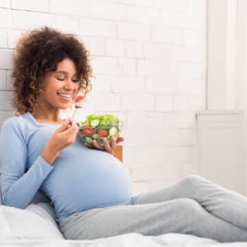Woman eating nutritious salad while pregnant
