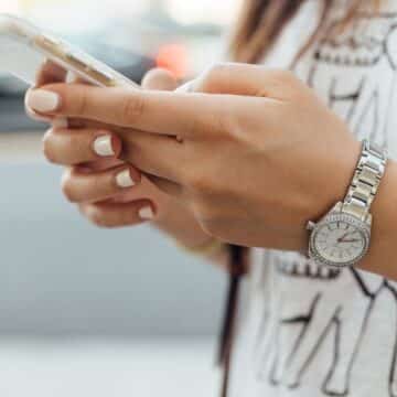 Woman wearing white holding her phone