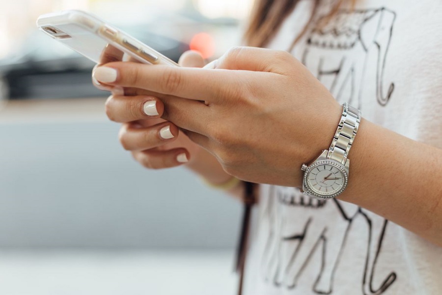 Woman wearing white holding her phone